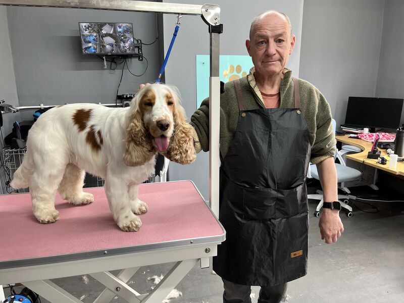 Keith Kershaw with a cocker spaniel in his home grooming salon